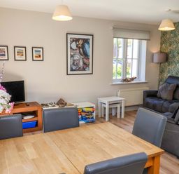 A living room with a sofa and dining table at Driftwood in Filey