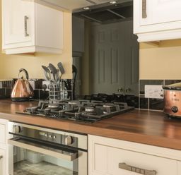 A kitchen countertop with a gas stove oven utensils toaster kettle and slow cooker at Arbour Retreat in Filey