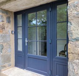 An entrance with double doors and a stone wall at Pen Y Cefn
