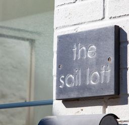 A close up of a wall sign that says the sail loft on a white brick wall at The Sail Loft in St Ives