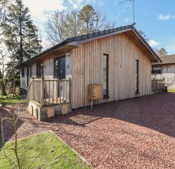 A wooden house with a garden and decking at Barn Owl in Otterburn