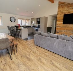 A living room with a sofa and dining area at Barn Owl in Otterburn