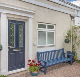 A blue door with a blue bench outside and plants in pots at Barwood View in Torquay