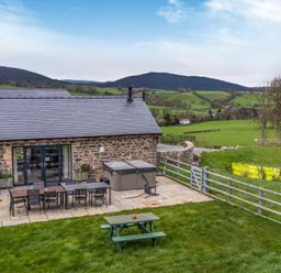 An outdoor area with a table and chairs at Bwthyn Y Bugail (Shepherd's Cottage) Pedairffordd near Llanrhaeadr-Ym-Mochnant