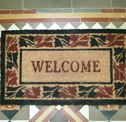 A welcome doormat on a patterned tiled floor at Sunnymeade in Buxton Norfolk