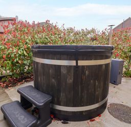 A hot tub with steps and plants in the garden at Plough Cottage Little Kelk near Bridlington