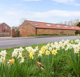 An outdoor view with flowers and a building at Plough Cottage in Little Kelk near Bridlington