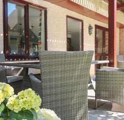 A patio area with wicker chairs and a table outside a building at 32 Trevithick in Hayle