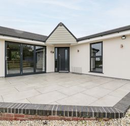 A tiled patio area with black framed glass doors and windows at Strawberry Stables in Iwood near Congresbury