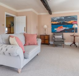 A living room with a grey sofa and armchairs two wooden side tables with lamps and an abstract painting on the wall at Field Head House in Graythwaite near Hawkshead