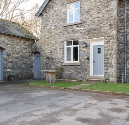 A stone cottage with blue doors and windows and a small patch of grass at Briar in Graythwaite near Hawkshead