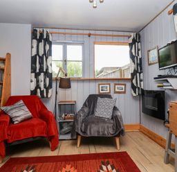 A living room with two armchairs and a shelf at Tiny Willow in Farrington near Child Okeford