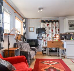 A living room with a sofa and a kitchen area at Tiny Willow in Farrington near Child Okeford