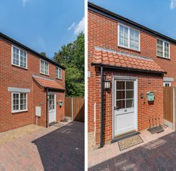 The front exterior of a red brick house with white framed windows a white door a red tiled canopy a green mailbox and a wooden fence at 26 Burtons Mill in Stalham