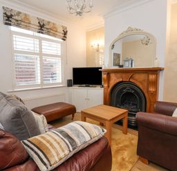 A living room with leather sofas a wooden coffee table a fireplace and a TV at 202 Salisbury Terrace York