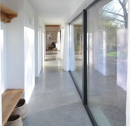 A hallway with a wooden bench and baskets and a glass wall with curtains at High Cogges Farm Holiday Cottages - The Cart Shed in High Cogges near Witney