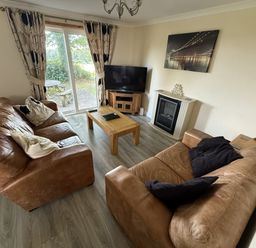 A living room with sofas and a television at Hembry Meadows in Honicombe Park near Gunnislake
