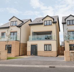 Three modern detached houses with balconies and driveways at Amble Views in Amble
