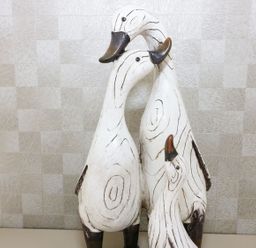 A group of three wooden duck sculptures against a textured wall at 44 Heritage Park in Stepaside near Kilgetty