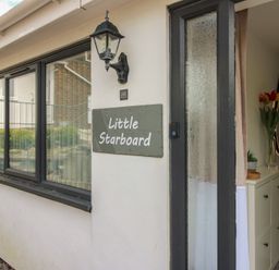 An entrance with a house sign and plants at Little Starboard in Kingsbridge