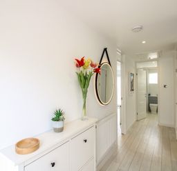 A hallway with a mirror and flowers at Little Starboard in Kingsbridge