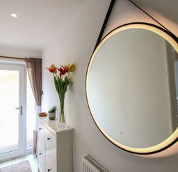A hallway with a mirror and flower vase at Little Starboard in Kingsbridge