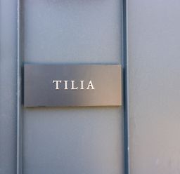 A black nameplate with the word TILIA on a blue door at Tilia Barn in Wincanton