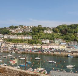 A harbor with boats and buildings along the waterfront at Pixie Cottage in Looe