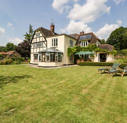 A large house with a well-kept lawn outdoor seating and sun loungers at Valley House in Devizes