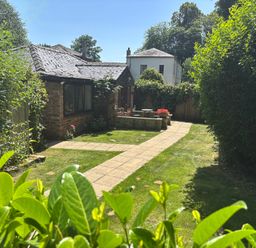 A garden with a pathway and flower planter at Claire Cottage in Gateforth near Hambleton, North Yorkshire
