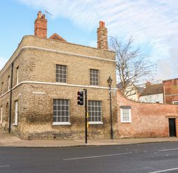 A brick building on a street corner with traffic lights and a sidewalk at Enterprise House in Bury St Edmunds