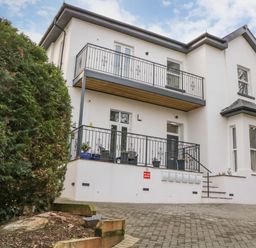 Outside view of a two story house with balconies and a paved driveway at Riviera Heights in Paignton