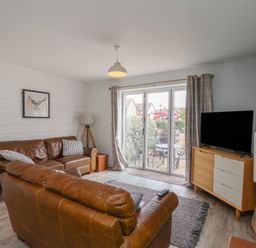 A living room with a sofa and a television at Buck Place The Bay - Filey