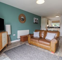 A living room with a sofa and television at Buck Place The Bay - Filey