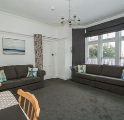 A living room with two brown sofas and sea themed cushions at Northgate Ground Floor Flat in Hunstanton