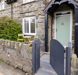 An outdoor area with a gate and bistro seating at Y Bwthyn in Llanbedr