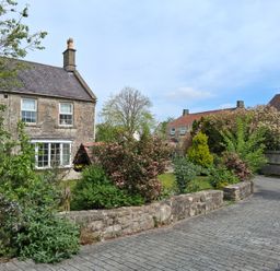 A garden with houses and pathway at Crooked Well in Timsbury, Nr Bath