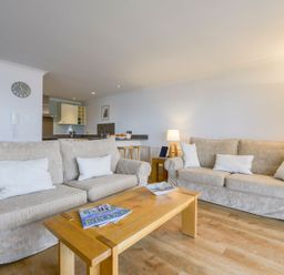 A living room with two beige sofas and a wooden coffee table at 17 Burgh Island Causeway in Bigbury-On-Sea
