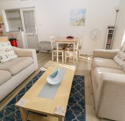 A living room with two sofas a wooden coffee table and a dining table with chairs at Ballasalla in Liskeard