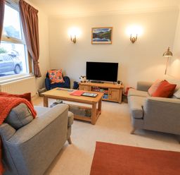 A living room with two sofas a television and a coffee table at Holme Rigg in Braithwaite