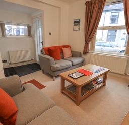 A living room with two sofas a wooden coffee table and patterned curtains at Holme Rigg in Braithwaite