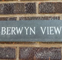 A metal sign with the text Berwyn View mounted on a brick wall at Berwyn View in Trelydan near Welshpool