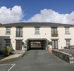 A two-story building with balconies and a driveway archway at Harbour View in Porthmadog