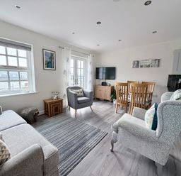 A living room with a television and dining area at Harbour View in Porthmadog