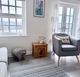 A living room with a sofa and an armchair at Harbour View in Porthmadog
