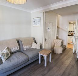 A living room with a sofa and coffee table at Heath Cottage in Stratford-Upon-Avon