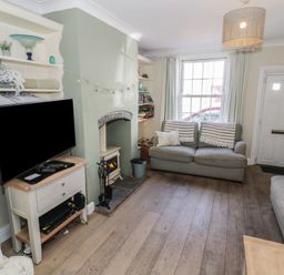 A living room with a television and a fireplace at Heath Cottage in Stratford-Upon-Avon