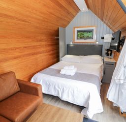 A bedroom with a bed and couch at Willow Lodge At Bridge Lake Farm & Fishery Chacombe