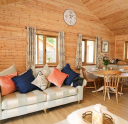 A wooden interior living room with a striped sofa and colorful cushions at The Larches Van near Llanidloes