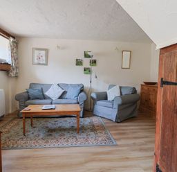 A living room with a sofa and armchair at The Old Bakery in South Perrott near Mosterton